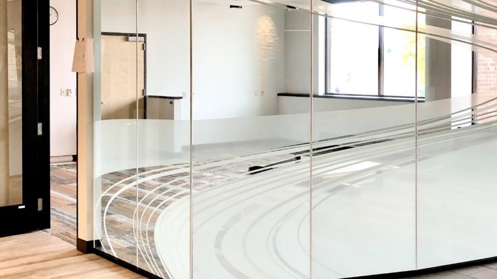 Glass-walled conference room with decorative frosted privacy film in a curved band pattern, installed by Sun Control